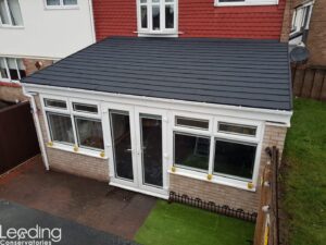 Conservatory with black tiled roofing and guttering